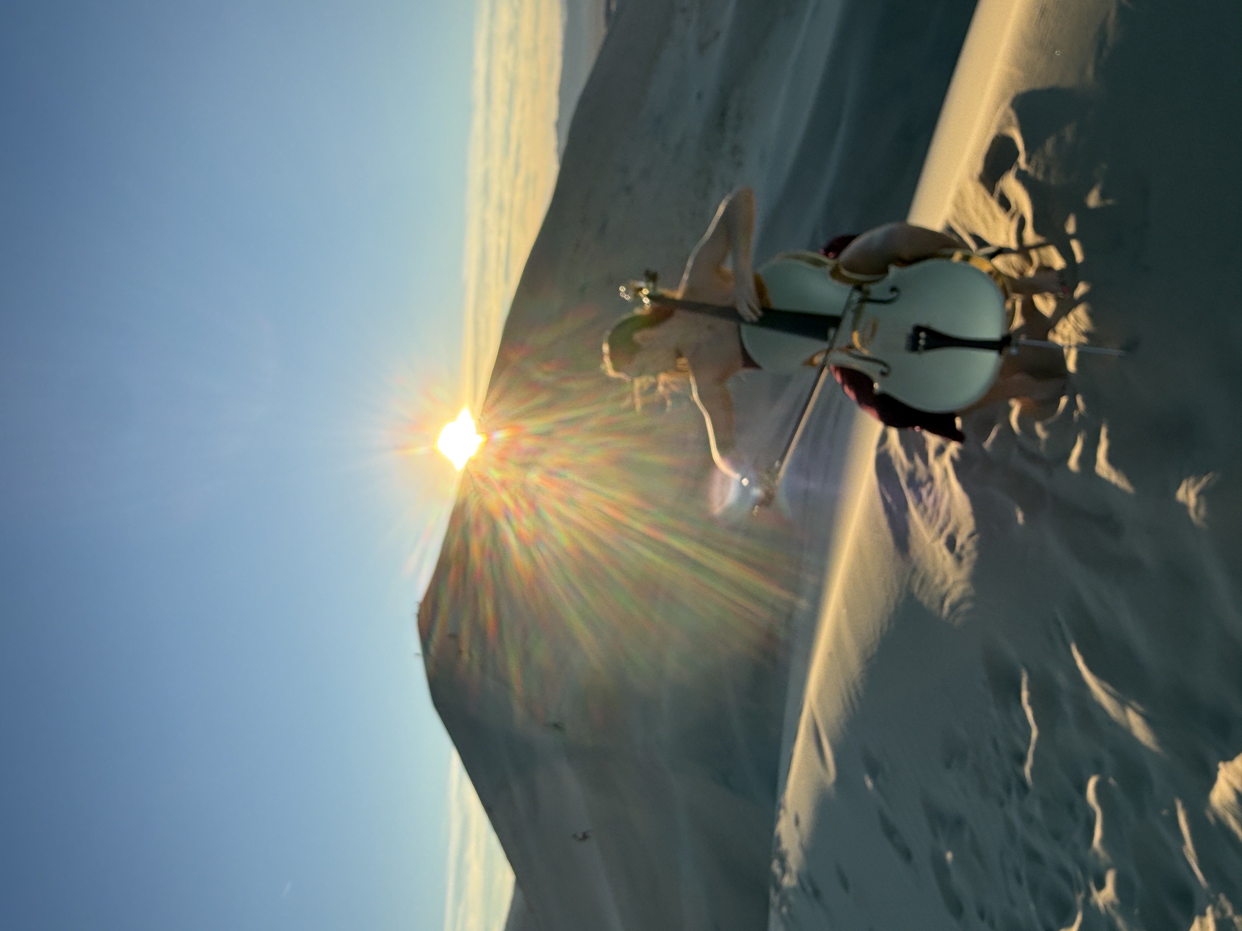 Ethereal sunset performance on sand dunes with sunburst